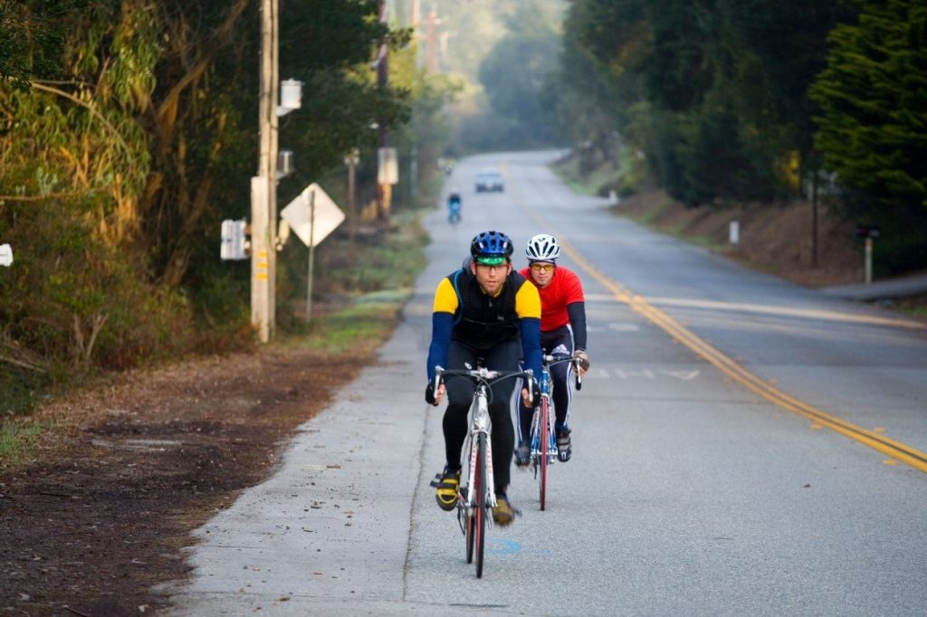 Two road cyclists on an open road.