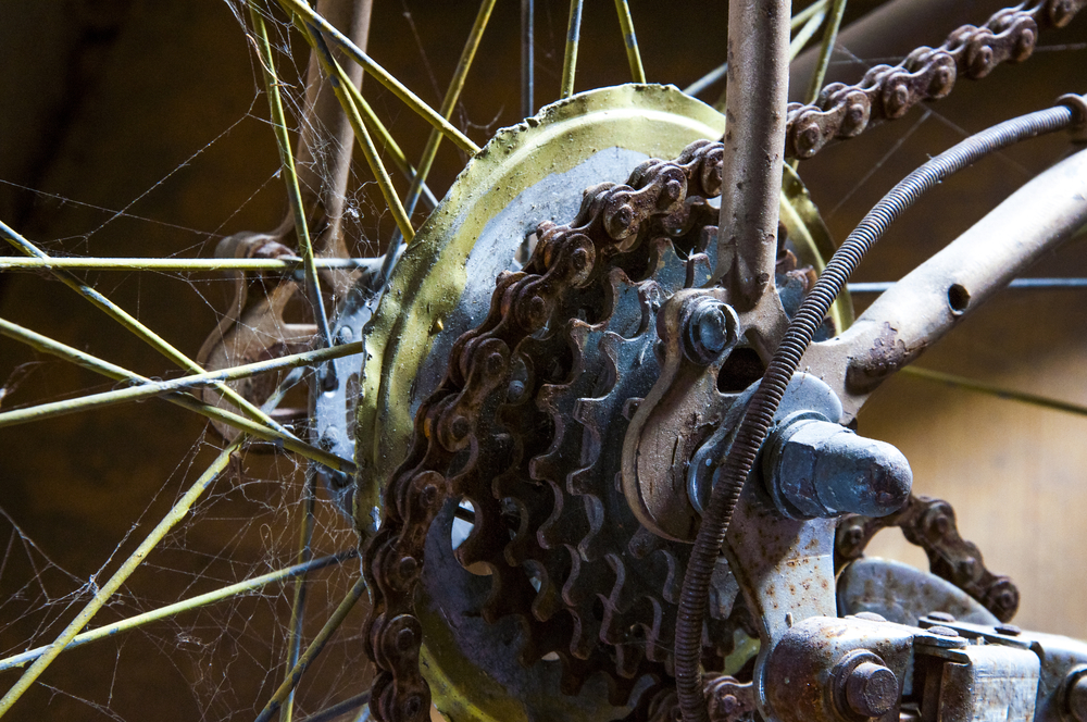 Image of an old rusty chain and cassette on a beat up bike. 