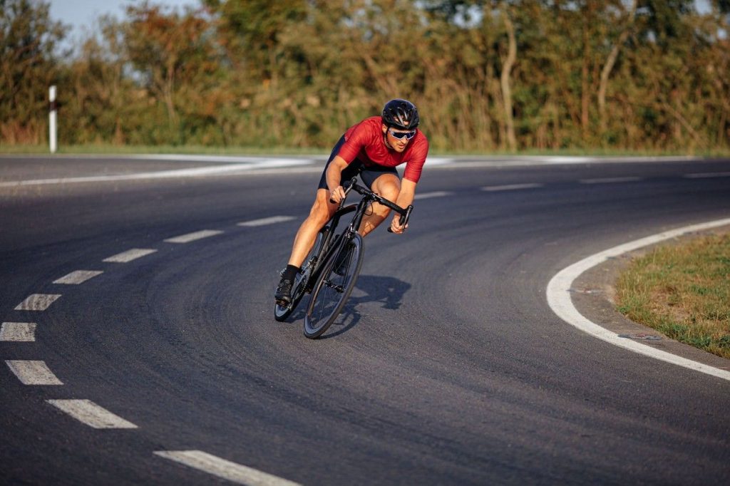 A lone male road cyclist riding on the road